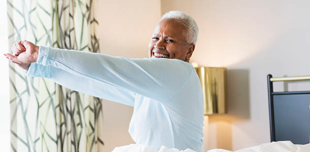 minority_senior_waking_up_stretching_refreshed woman stretching in bed