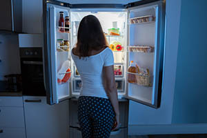 sleep eating disorder - woman at refridgerator