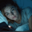 Women in bed looking at phone screen, screen time and sleep